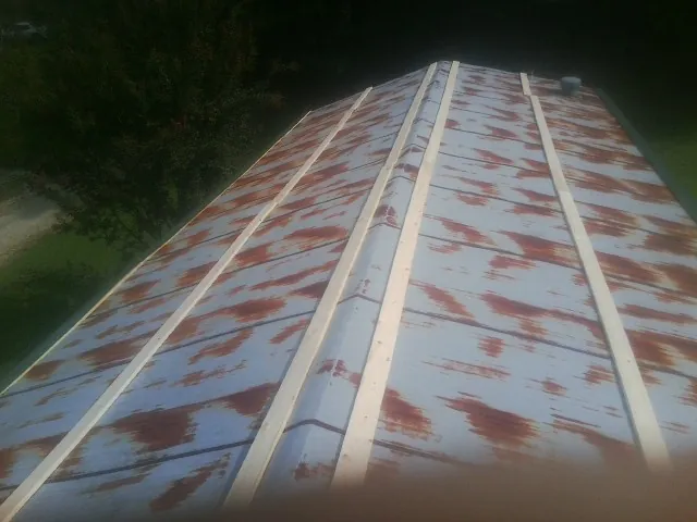 Rusted metal roof panels with new wood purlins before replacement — Storm Damage Roof Repair in Vermillion by Roofing Brothers