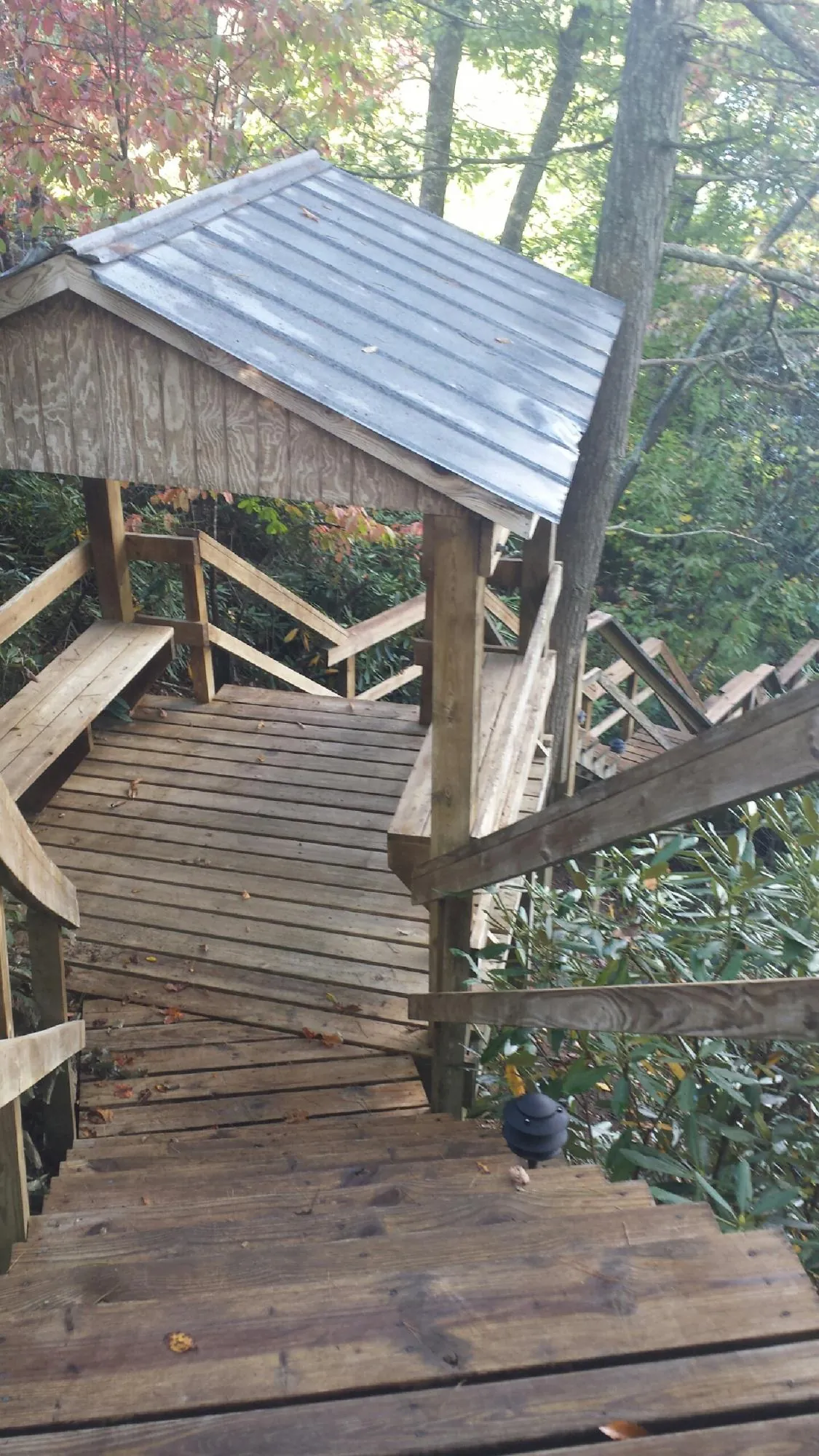 Metal roofed shelter over wooden steps on a wooded walkway — Skylight Repair & Installation work by our crew in Vermillion